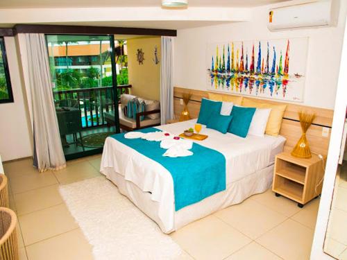 1 dormitorio con 1 cama grande con sábanas azules y blancas en Porto Beach Resort - Marulhos, en Porto de Galinhas
