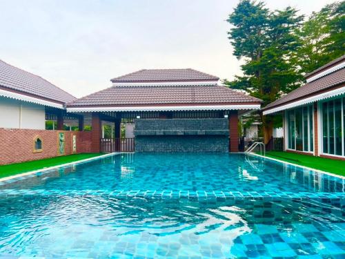 una piscina frente a una casa en Keang Khuen Pool Villa Pran เคียงคลื่น พูลวิลล่า ปราณ, en Ban Nong Ban Kao