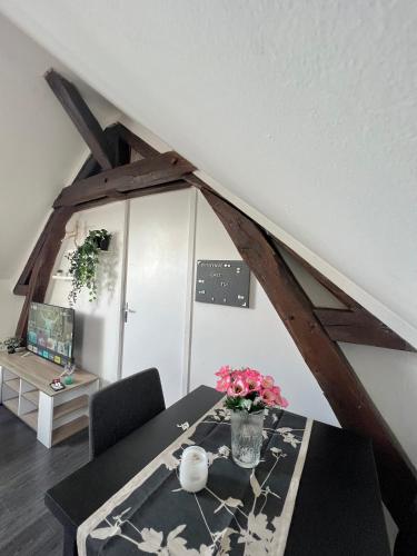 une pièce avec une table avec un vase de fleurs dessus dans l'établissement Bel appartement lumineux 35m2, Bord De Loire, à Saint-Jean-le-Blanc