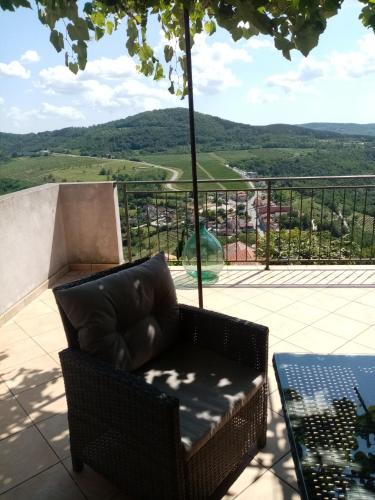 a chair and a table on a balcony with a view at Studio apartman Bel Vedere in Motovun