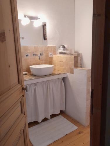 La salle de bains est pourvue d'un lavabo blanc et d'un miroir. dans l'établissement Le mas Lou Caïroun, un paradis en Provence, à Aubignan