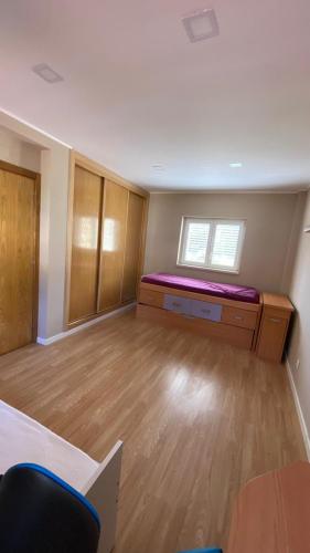 an empty room with a bed and a window at Varandas de Troia in Troia