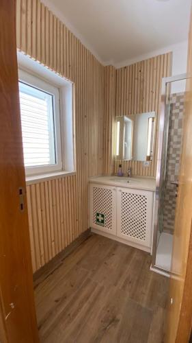 a bathroom with a sink and a mirror and a window at Varandas de Troia in Troia