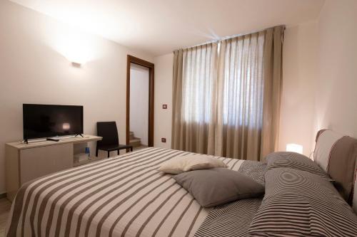 a hotel room with a bed and a television at Maison Croix de Ville in Aosta