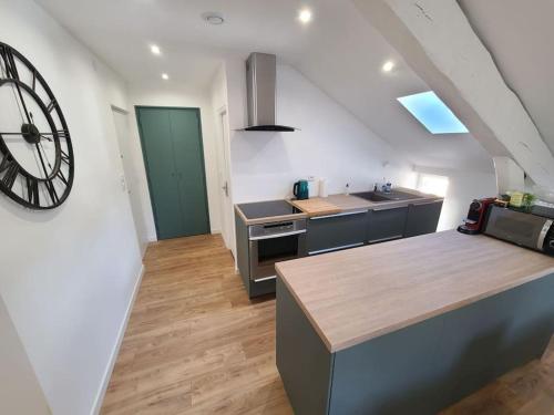 une cuisine avec une grande horloge murale dans l'établissement Meublé de tourisme 2 chambres AIX LES BAINS, à Aix-les-Bains