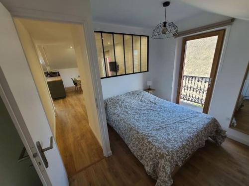 um quarto com uma cama e uma grande janela em Meublé de tourisme 2 chambre AIX LES BAINS em Aix-les-Bains