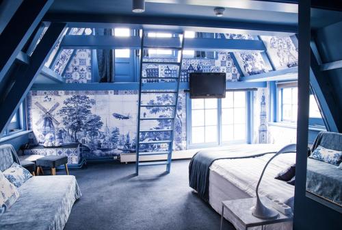 um quarto com paredes azuis e uma cama e uma televisão em 't Hotel em Amsterdã