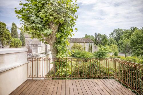 a wooden walkway with a tree on a fence at La Nauve, Hôtel & Jardin - Relais & Châteaux in Cognac