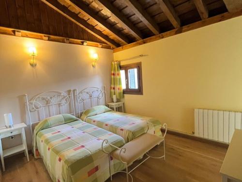 two beds in a room with yellow walls at Los Secretos de Lua 