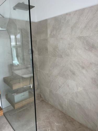 a shower with a glass door in a bathroom at HOTEL CA'N UETAM in Valldemossa