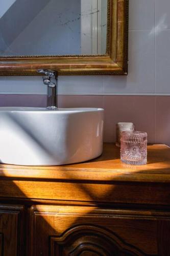 a bathroom sink on a wooden counter with a mirror at Manoir d'Egrefin in Saint-Martin-dʼAbbat