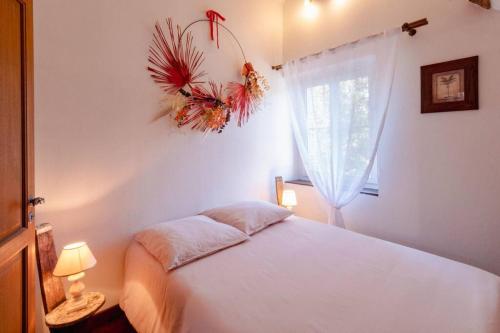 um quarto com uma cama branca e uma janela em Manoir d'Egrefin em Saint-Martin-dʼAbbat