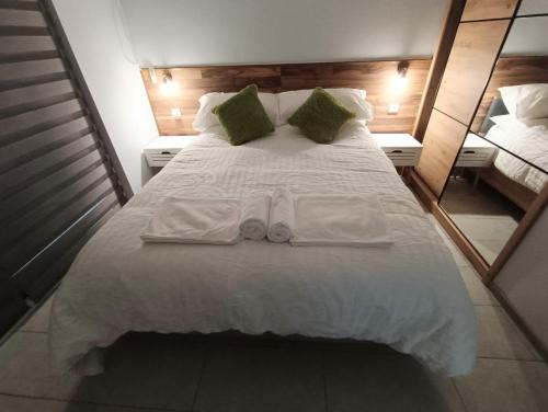 a large white bed with two towels and two mirrors at Carefree Apartments in Ulcinj