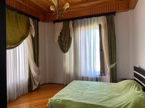1 dormitorio con 1 cama y 2 ventanas grandes en Astara Paradise Villa, en Astara
