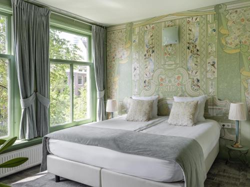 - une chambre avec un grand lit, des murs verts et des fenêtres dans l'établissement 't Hotel, à Amsterdam