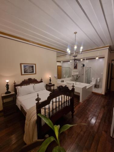 a bedroom with a large bed and a bathroom at Teatro Hotel Boutique in Ouro Preto