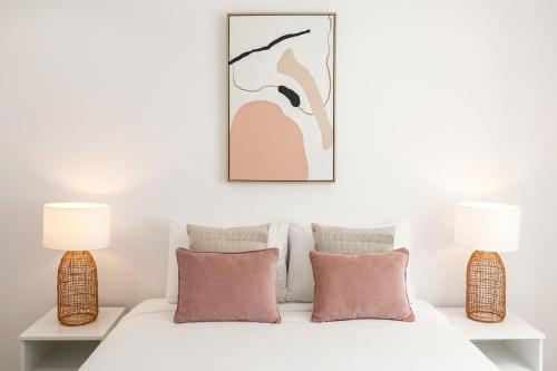 a bedroom with two lamps and a bed with pillows at O Sítio do Tomás in Nazaré