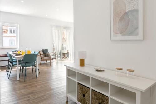 a white living room with a table and chairs at O Sítio do Tomás in Nazaré