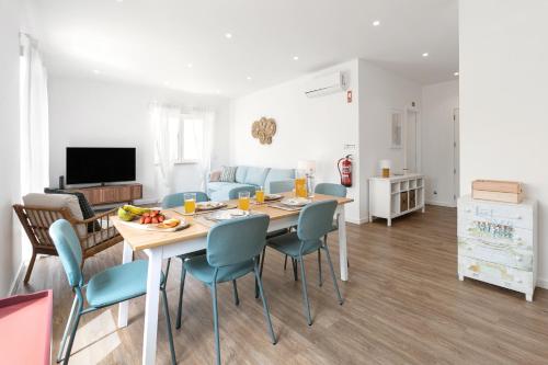 a dining room and living room with a table and chairs at O Sítio do Tomás in Nazaré