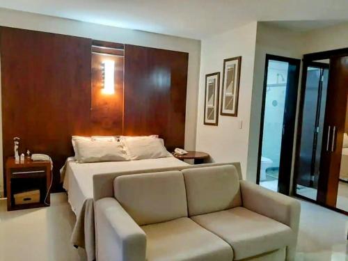 a bedroom with a bed and a couch at Flat LakeSide -Vista para o lago C17 in Brasilia