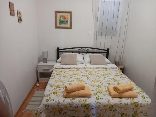 ein Schlafzimmer mit einem Bett mit zwei Kissen darauf in der Unterkunft Kuća za odmor Skalina in Splitska