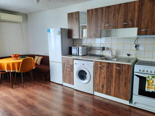 uma cozinha com uma máquina de lavar roupa e uma sala de jantar em Eleny home em Burgas