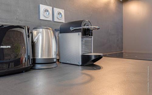 um balcão de cozinha com comodidades para preparar café e uma torradeira em Les suites locarno em Limoges
