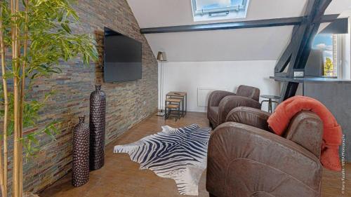 una sala de estar con 2 sofás y una pared en Les suites locarno en Limoges