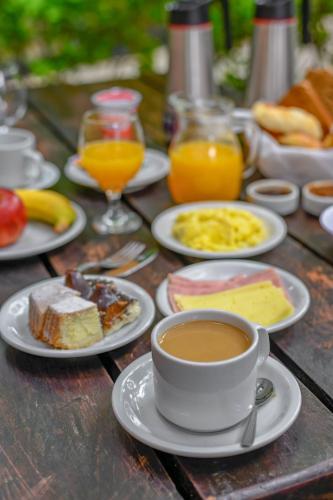 a table with plates of food and a cup of coffee at Carilo Hills by bund in Carilo