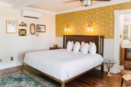 a bedroom with a large white bed and a fireplace at The Gibson Inn in Apalachicola