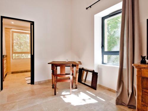 Zimmer mit einem Tisch, einem Fenster und einem Spiegel in der Unterkunft La bambouseraie de sulauze in Miramas