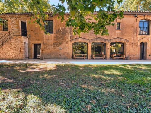 an old brick building with a lawn in front of it at La bambouseraie de sulauze in Miramas