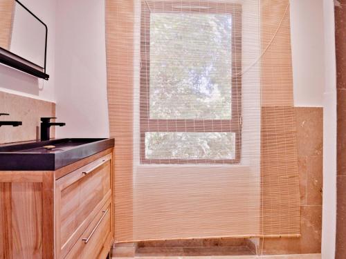 a bathroom with a shower with a sink and a window at La bambouseraie de sulauze in Miramas