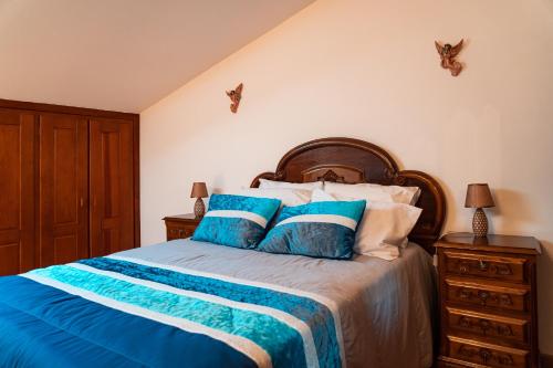 a bedroom with a bed with blue and white pillows at Casa Malheiro in Ponte de Lima