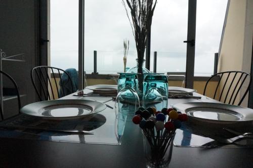une table avec un vase en verre sur une table dans l'établissement BELLE VIE vue dominante mer et plage - Appartement 2 à 4 personnes, à Cabourg