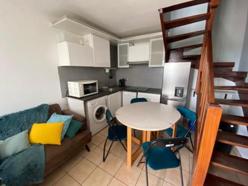 un salon avec une table et des chaises et une cuisine dans l'établissement Quai de l'étang, à Gruissan