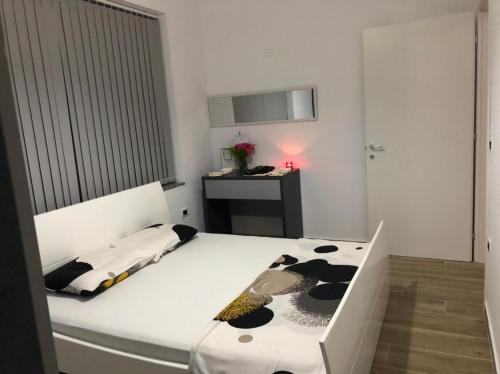 a bedroom with a black and white bed and a desk at Ornela Apartments in Durrës