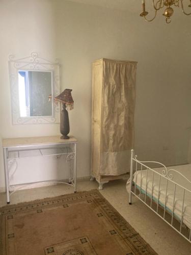 a bedroom with a bed and a table with a lamp at La Marsa Maison avec jardin, terrasse parking Wifi Illimité in La Marsa