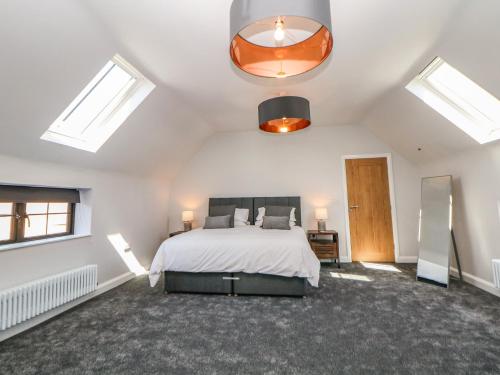 ein Schlafzimmer mit einem Bett und zwei Oberlichtern in der Unterkunft Langley Barn in Ashbourne