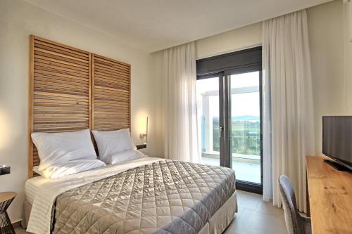 a bedroom with a large bed and a television at Villa Acropolitana by PosarelliVillas in Acharavi