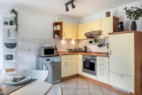 a small kitchen with yellow cabinets and appliances at Weitblick in Breitnau