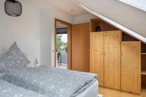 1 dormitorio con 1 cama y armarios de madera en Weitblick en Breitnau