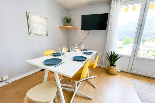 uma sala de jantar branca com uma mesa branca e cadeiras amarelas em The Palmeraie Garden Parking #DF em La Tronche