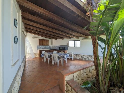 a patio with a table and chairs in a house at Villa Lucia Fontane Bianche in Fontane Bianche