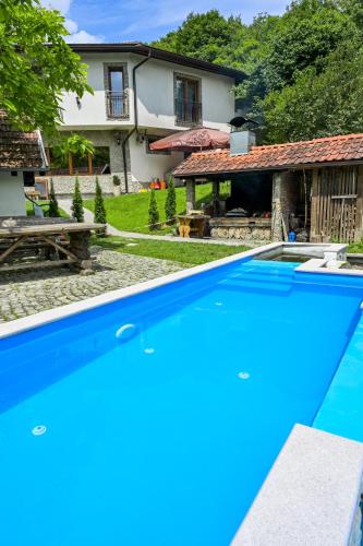 a large blue swimming pool in front of a house at Prenoćište Slapovi in Jajce
