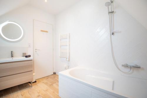 une salle de bain blanche avec une baignoire et un lavabo dans l'établissement Grand Duplex Gare TGV & Centre ville par Groom*, à Lorient