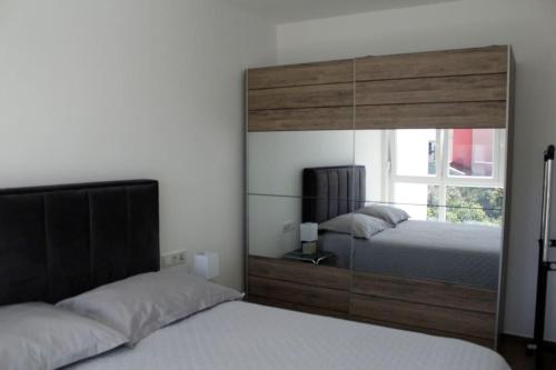 sypialnia z 2 łóżkami i dużym lustrem w obiekcie Apartman Karmen w mieście Brodarica