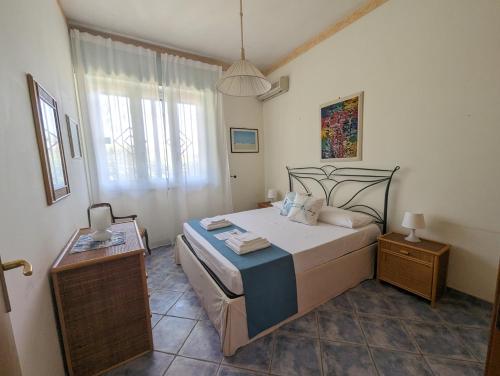 a bedroom with a large bed and a window at Villa Lucia Fontane Bianche in Fontane Bianche