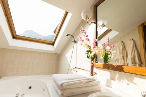 a bathroom with a sink and a bath tub with a window at Hotel Paris in Encamp