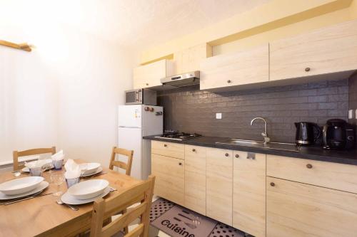 une cuisine avec une table en bois et un réfrigérateur dans l'établissement Chalet Belamy Studio 1, à Courchevel